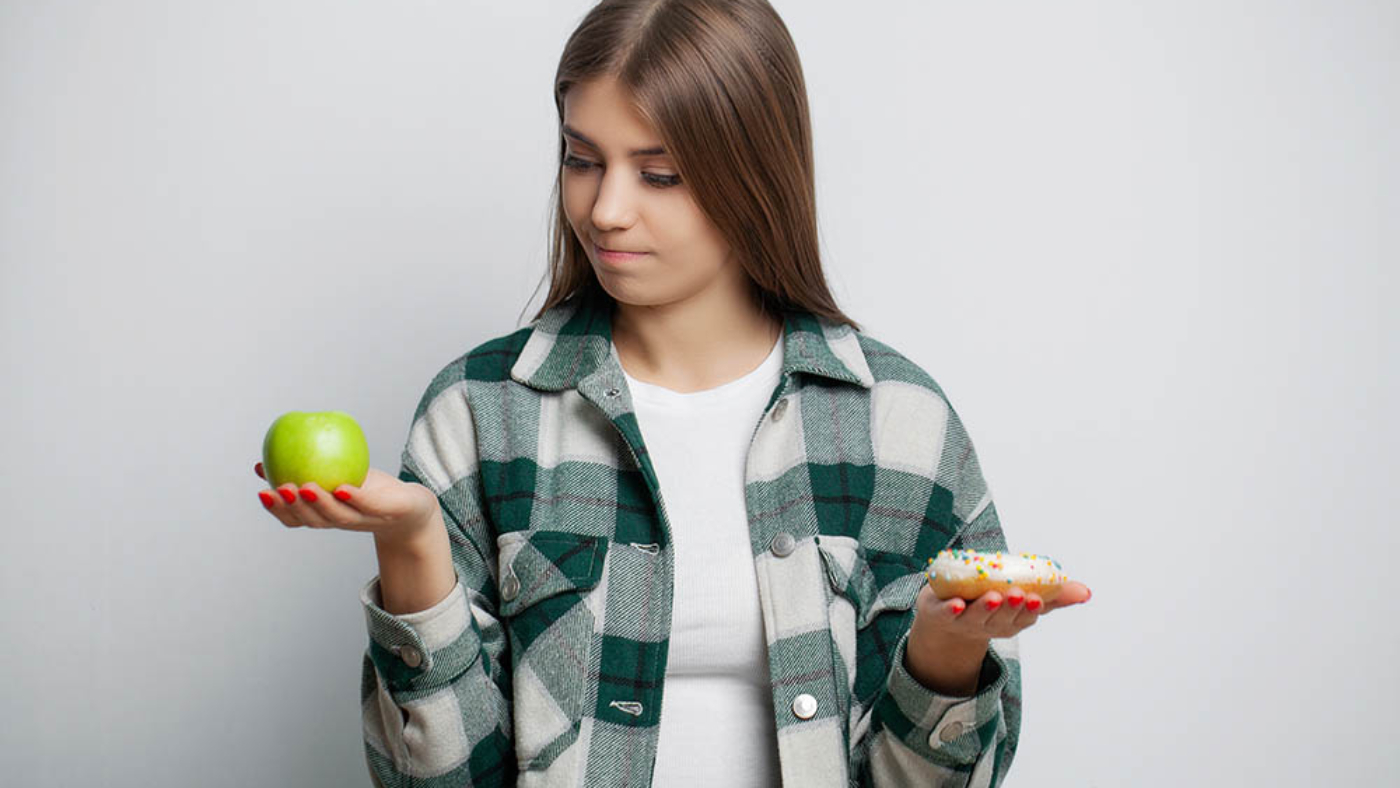 Cute woman makes a choice between healthy and harmful food.